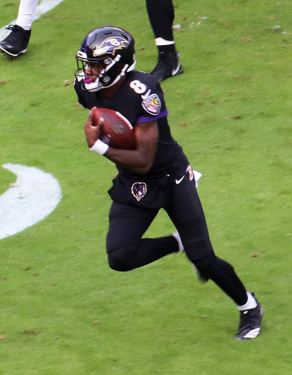 Lamar Jackson running with the football during an NFL game